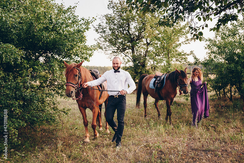 A loving couple on a date. Horseback riding. Purple dress. © malysheva