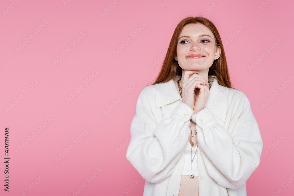 Pleased red haired woman in necklaces and jacket isolated on pink Pleased red haired woman in necklaces and jacket isolated on pink