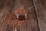 Buckwheat in a measuring glass on a wooden background