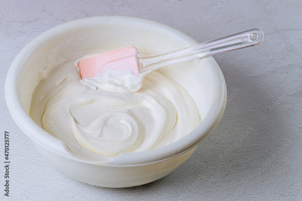 Homemade whipped cream in a bowl with spatula. Homemade whipped cream in a bowl with spatula.