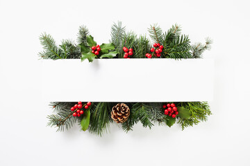 Composition of red holly berries and green branches on white background. Winter natural decoration.