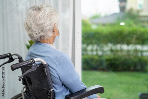 Bilde på lerret An elderly woman sitting on wheelchair looking out the window for waiting someone