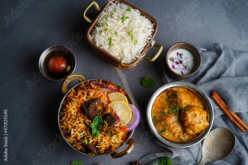 Indian veg non veg meal thali - mutton biryani, raita, malai kofta, basmati rice, and gulab jamun, selective focus