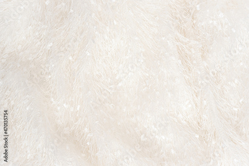 Texture of soft white plaid surface with long natural fur at bright light view from above. Blanket or clothes material closeup
