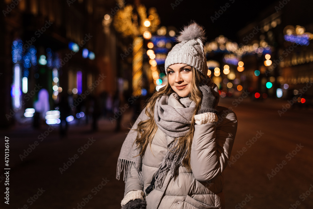 portrait of a beautiful woman against the background of the blurred lights of the city and cars. high quality photo