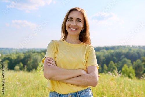 Portrait of an adult happy successful woman with folded hands.