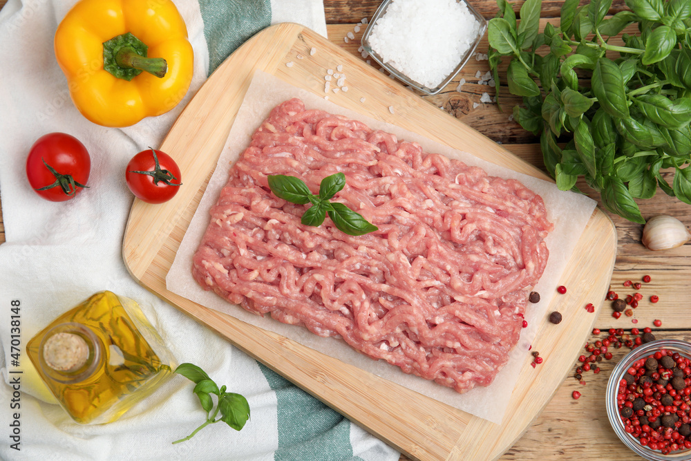 Raw chicken minced meat and ingredients on wooden table, flat lay Raw chicken minced meat and ingredients on wooden table, flat lay