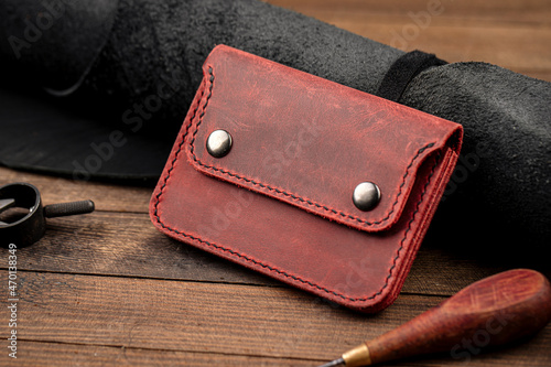 Hand crafted red leather wallet on the wooden background