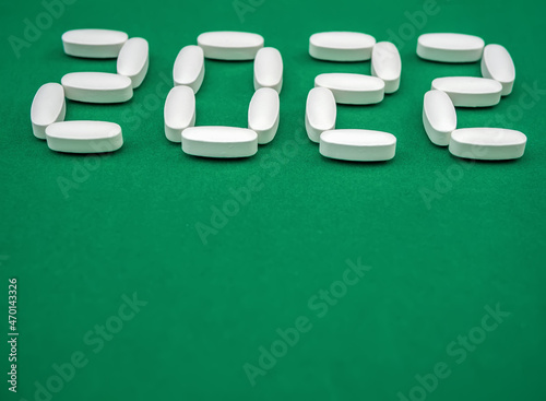 Lettering 2022 created by pills on the green background. Holiday decoration. photo