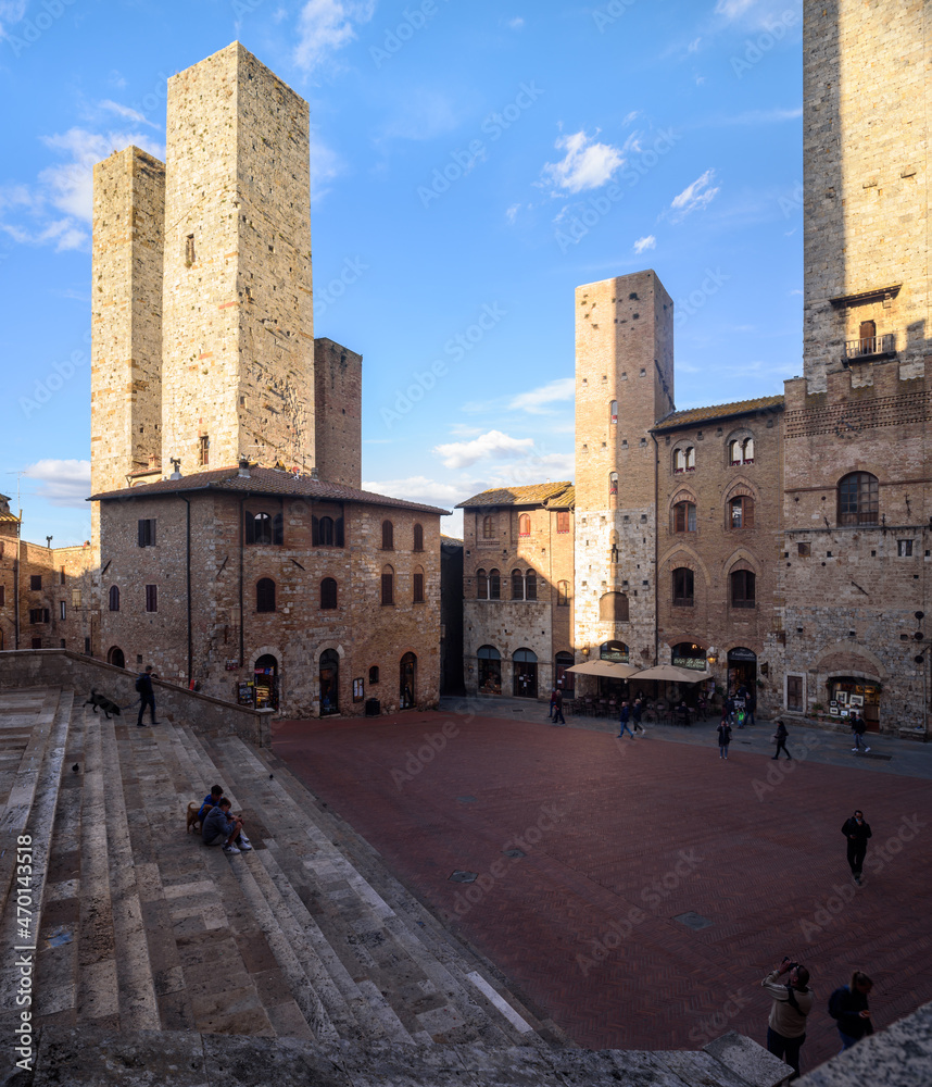 Geschlechtertürme, San Gimignano, Toskana, Italien bei Himmel mit Wolken und Sonne und Schatten.