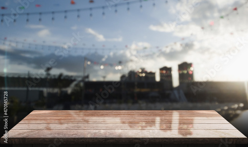 Empty wooden table top with lights bokeh on blur restaurant background.