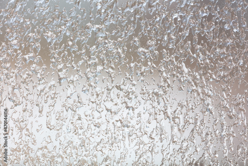 Obraz premium Frozen drops of water on a glass window as an abstract background.