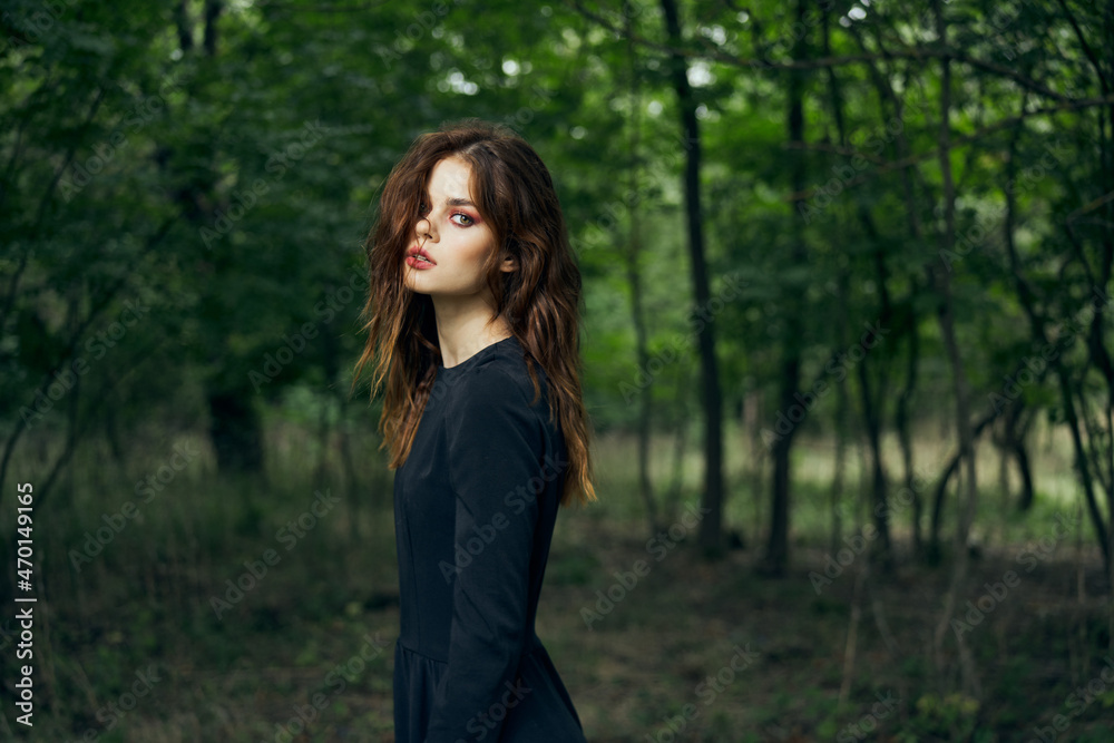woman in black dress in the forest Halloween Witch costume woman in black dress in the forest Halloween Witch costume
