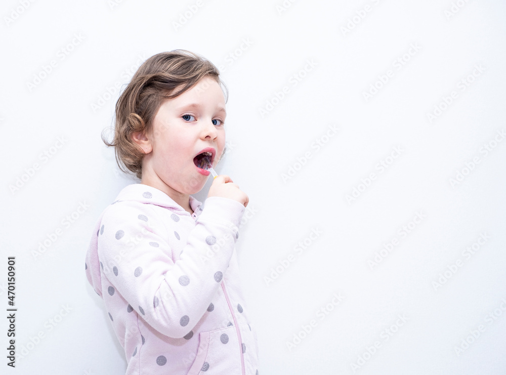 The child smiles and brushes his teeth with a toothbrush. Caucasian girl 6 years old, holding a toothbrush in her hands. The child smiles and brushes his teeth with a toothbrush. Caucasian girl 6 years old, holding a toothbrush in her hands.