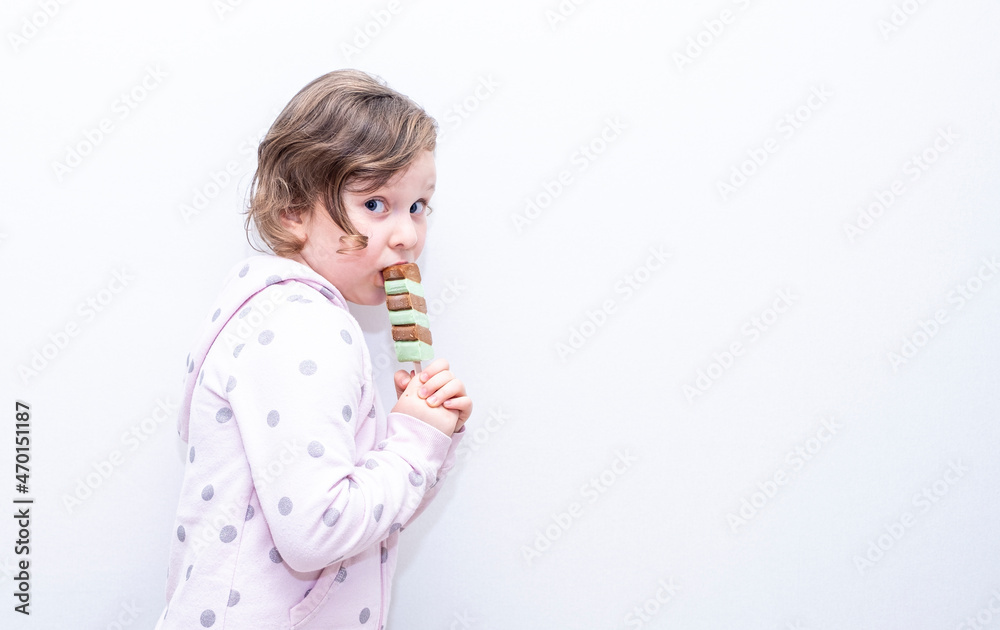 A child, a Caucasian girl, happily eats ice cream. A child, a Caucasian girl, happily eats ice cream.