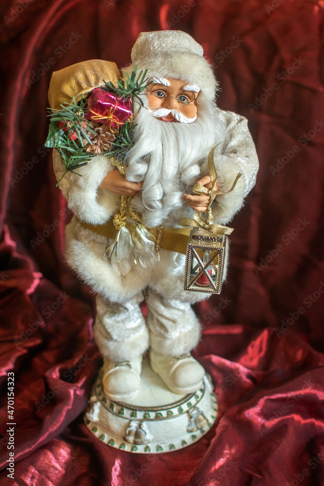 Santa Claus with a bag of gifts over his shoulder and a lantern in his hand