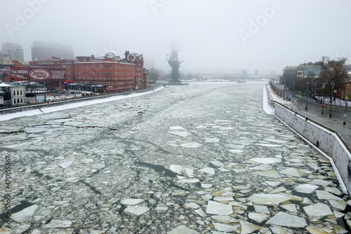 View  on the red brick building of the historic chocolate factory and the bronze monument to Peter the great on the Moscow river on a foggy winter morning. Misty winter morning in Moscow