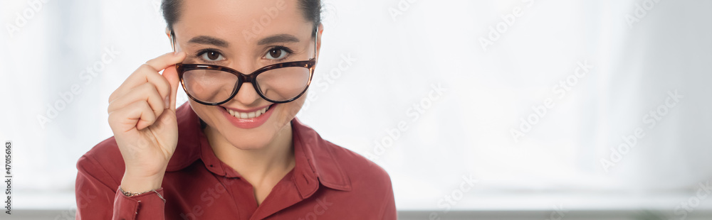 happy young teacher adjusting eyeglasses and looking at camera, banner. happy young teacher adjusting eyeglasses and looking at camera, banner.