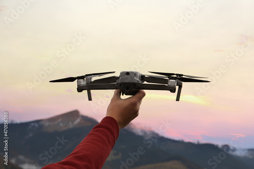 Man with modern drone in mountains, closeup