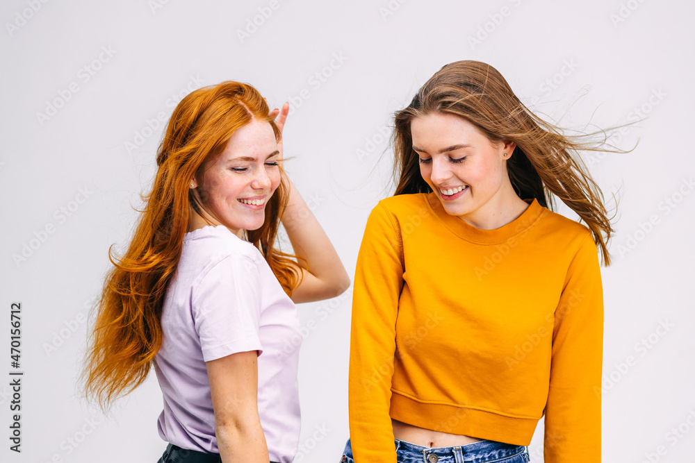 Two Young Girls friends in casual clothes are dancing, fooling a Two Young Girls friends in casual clothes are dancing, fooling a