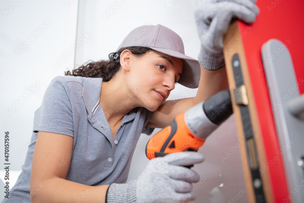 young carpenter woman using power drill young carpenter woman using power drill