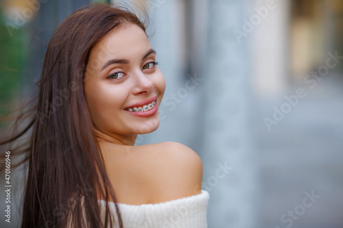 Beautiful Sexy Woman Wearing Fashionable Spring Or Fall Clothes  - White Warm Fluffy.  Model In Stylish Elegant Outfit Posing In Street Look In Camera. Copy, empty space for text. Blurred Details