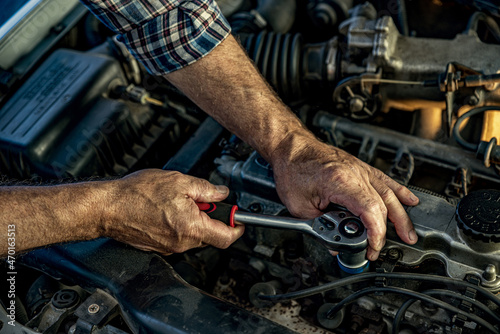 Repairman's male hands with a wrench. Vehicle fitter inspecting used car engine © TSViPhoto