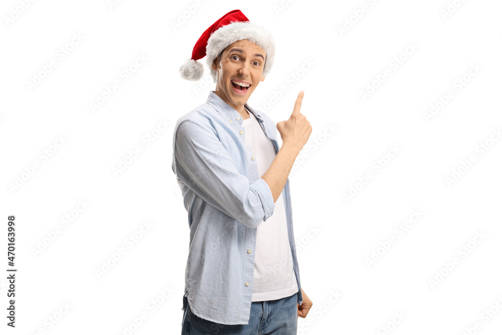 Young casual man with a santa claus hat smiling and pointing with finger Young casual man with a santa claus hat smiling and pointing with finger