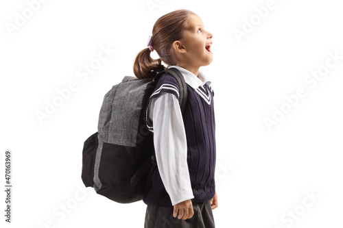 Amazed little schoolgirl looking up