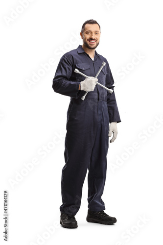 Full length portrait of an auto mechanic holding a lug wrench