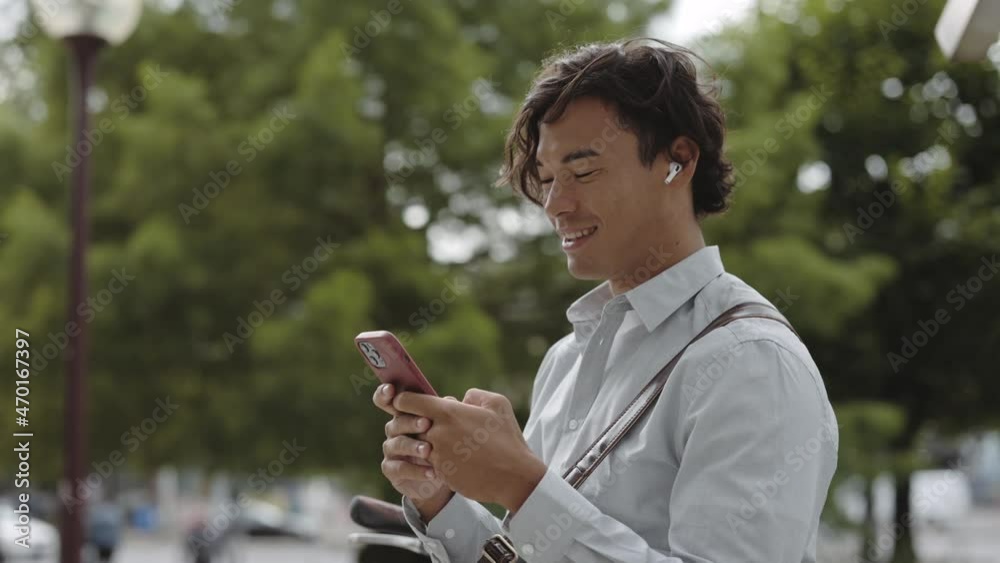 Businessman sitting near bike and texting on mobile outdoors Businessman sitting near bike and texting on mobile outdoors
