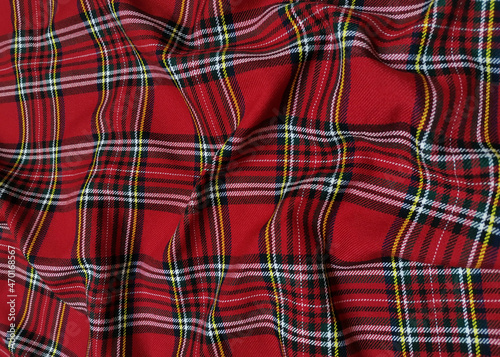 Red tartan woolen school uniform fabric material. Scottish classic seamless flannel cloth. Traditional wave pattern for a Christmas background or wallpaper. Black, Green, Red and White checkered.