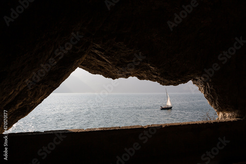 Sailboat sailing on the lake seen from a rock window © Restuccia Giancarlo