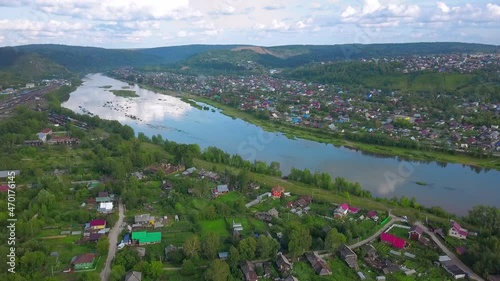 The view from the drone. Clip. Beautiful summer view of the blue lake, houses, mountains and blue sky. photo