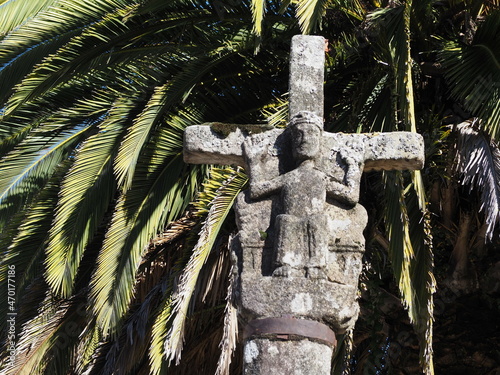 cruz de estilo románico y gótico con la escultura de jesús crucificado mirando al pueblo y en el reverso presenta a jesús majestad acompañado de dos figuras, en melide, la coruña, españa, europa photo