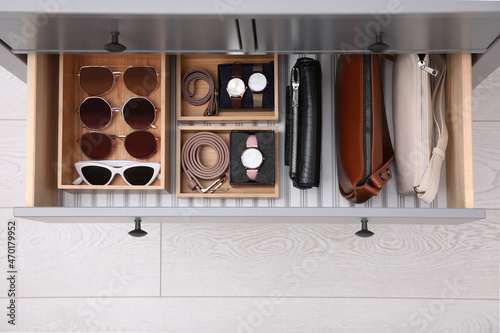 Open drawer with different stylish accessories indoors, top view. Storage and organizing photo