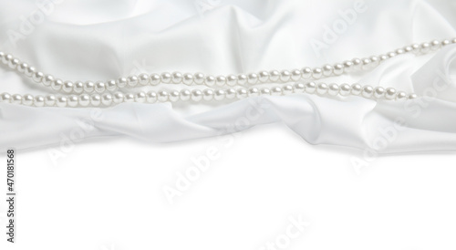 Beautiful pearls and delicate silk on white background