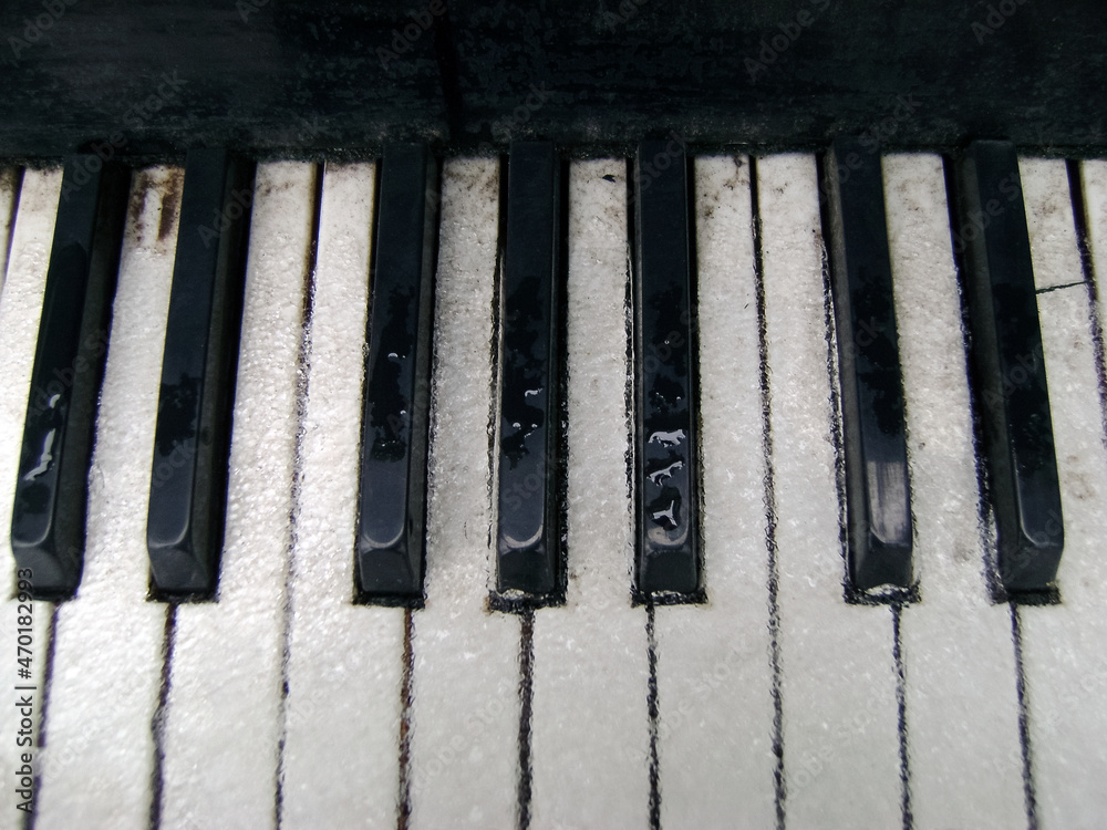 Outdoor grand piano on open air. Closeup. Ice, snow and water on the piano keys. The balance of notes is the key to an adequate melody. Outdoor grand piano on open air. Closeup. Ice, snow and water on the piano keys. The balance of notes is the key to an adequate melody.