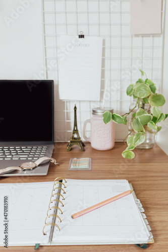 Home office desk with blank screen laptop, beautiful  plant leaves, planner, pencil, wrist watch, eiffel tower and office supplies on white background. Making plans concept.