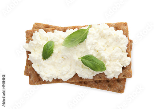 Fotografía Crispy crackers with cottage cheese and basil on white background, top view
