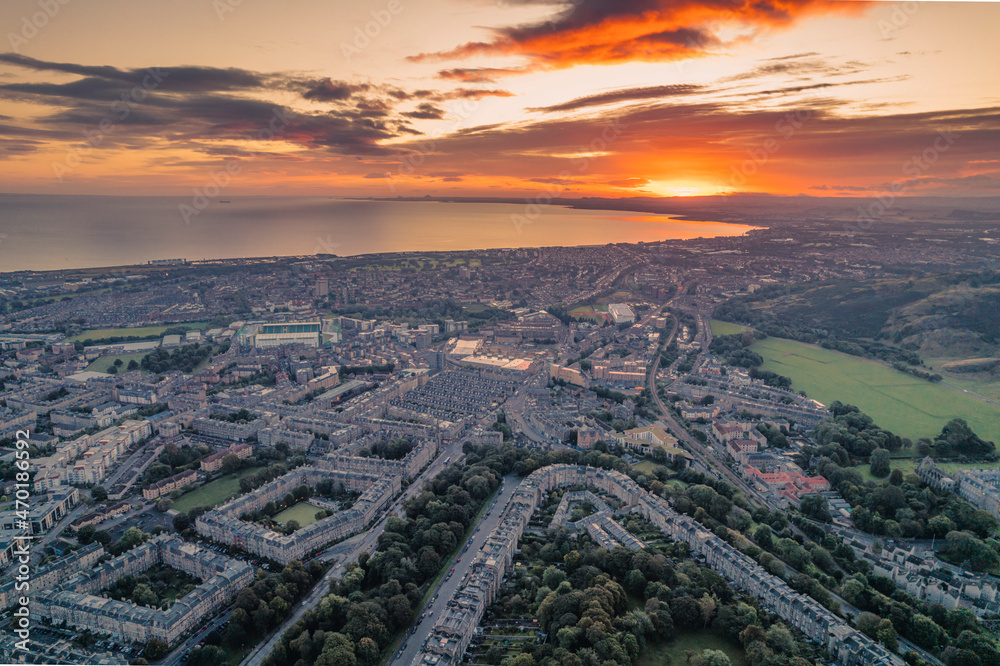 Aerial view of Edinburgh in the morning. Rising above the horizon, the sun radiates its warmth onto the city, highlighting all of its beautiful sights.  Great view on top Arthur's Seat morning sunrise