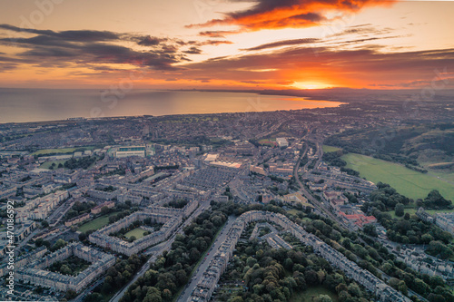 Aerial view of Edinburgh in the morning. Rising above the horizon, the sun radiates its warmth onto the city, highlighting all of its beautiful sights. Great view on top Arthur's Seat morning sunrise