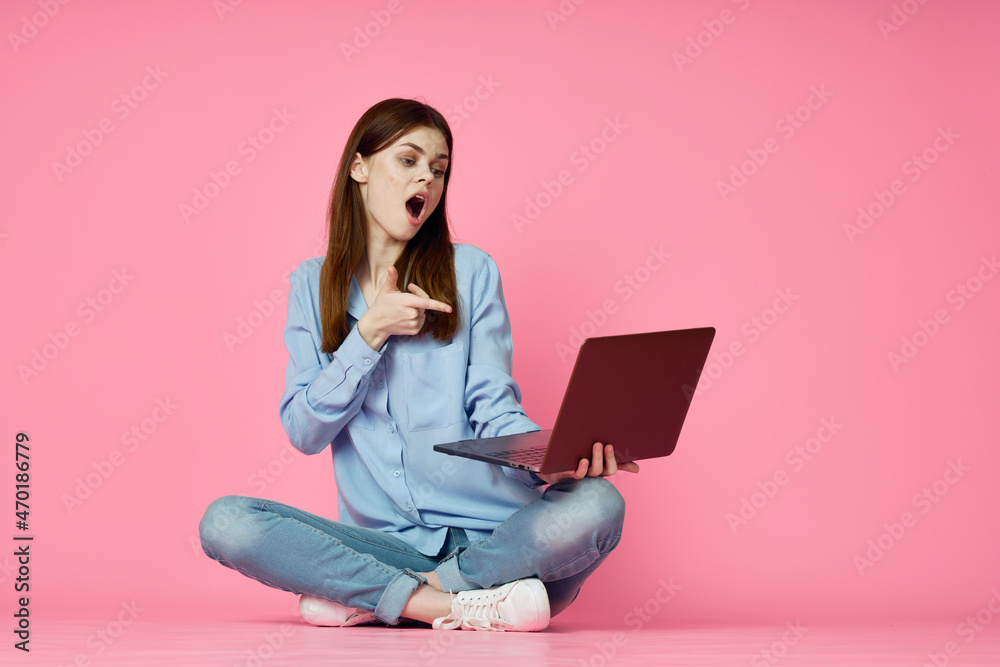 woman sitting on floor with laptop shopping entertainment pink background woman sitting on floor with laptop shopping entertainment pink background