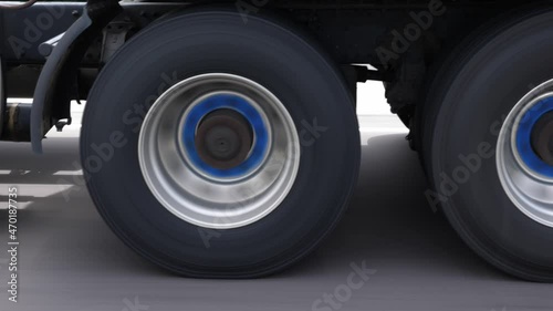Overtaking commercial truck or lorry. Detail of wheels with blue hubs. Highway driving in Ontario, Canada.