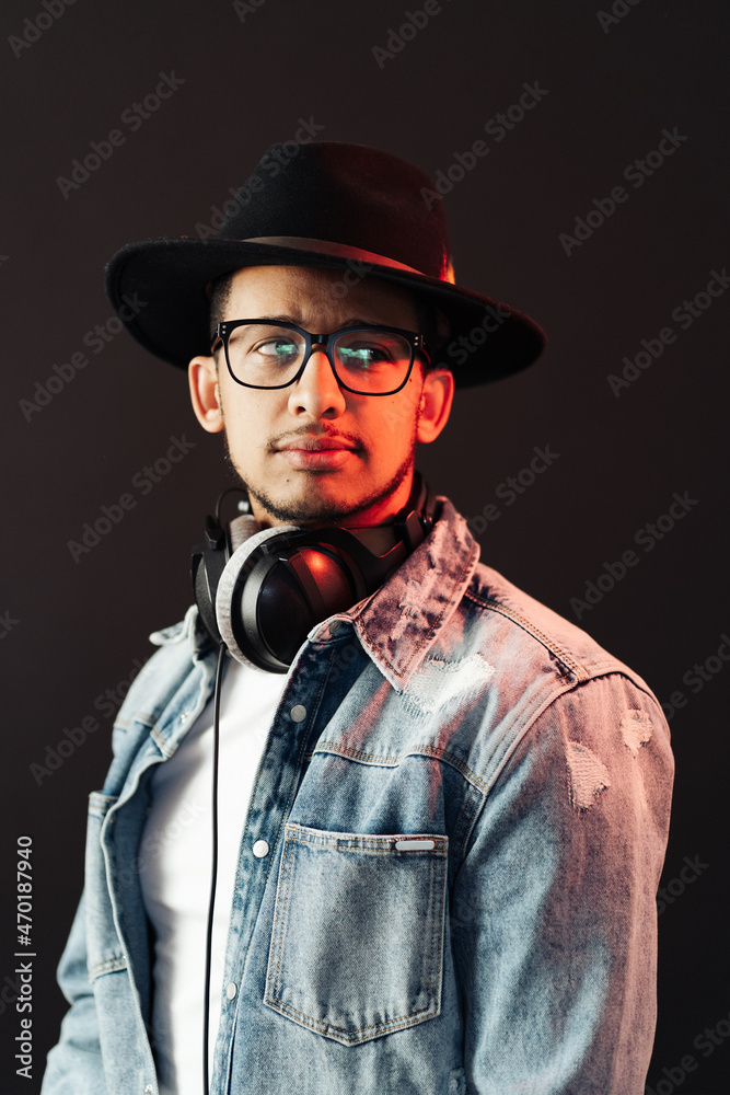 Young African American man portrait wearing headphones and hat and enjoy music over black Background Young African American man portrait wearing headphones and hat and enjoy music over black Background