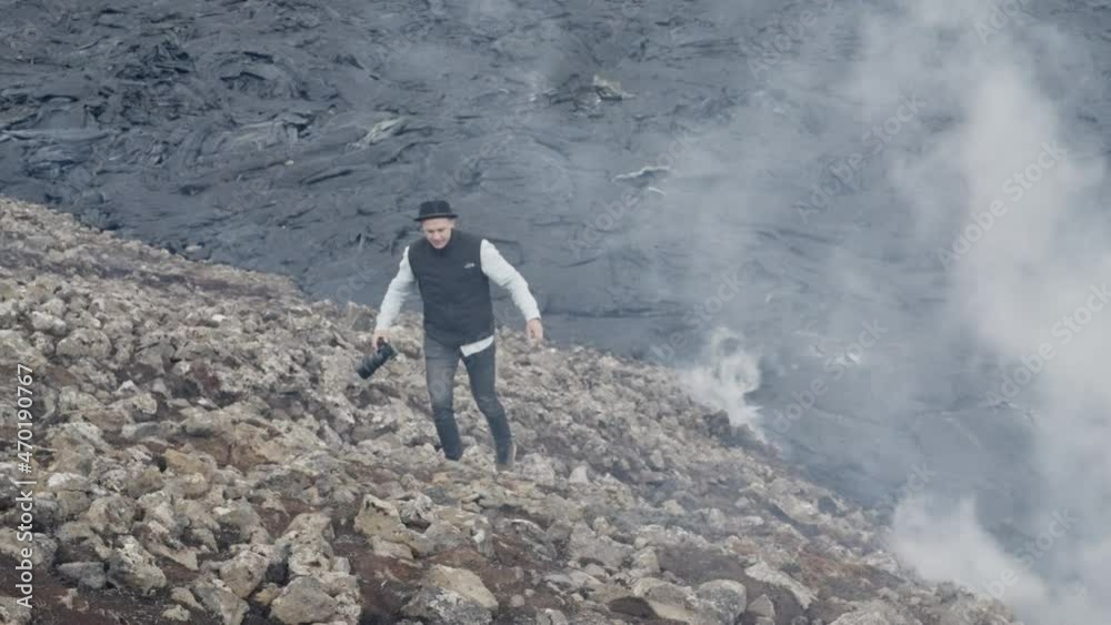 Photographer Walking As Smoke Rises From Lava Field Behind Photographer Walking As Smoke Rises From Lava Field Behind
