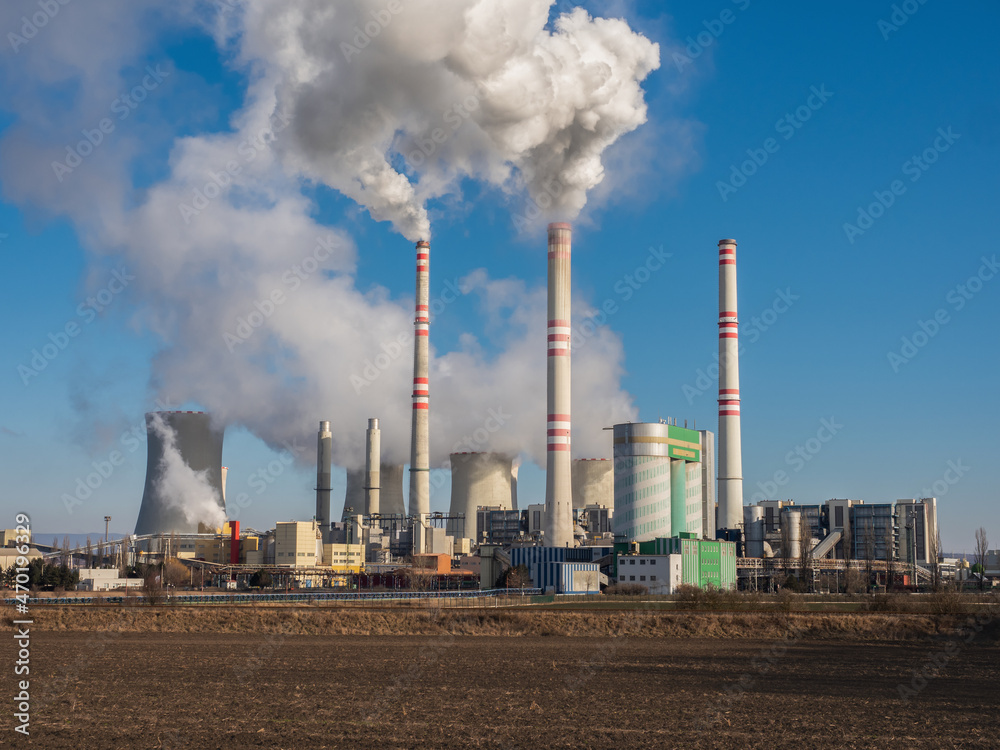 A coal-fired power station in the distance in agricultural landscape. Pocerady, Czech republic A coal-fired power station in the distance in agricultural landscape. Pocerady, Czech republic