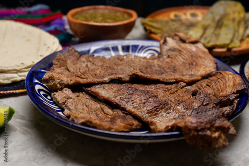 Beef steak called tampiqueña with cactus and onion on a gray background. Mexican food