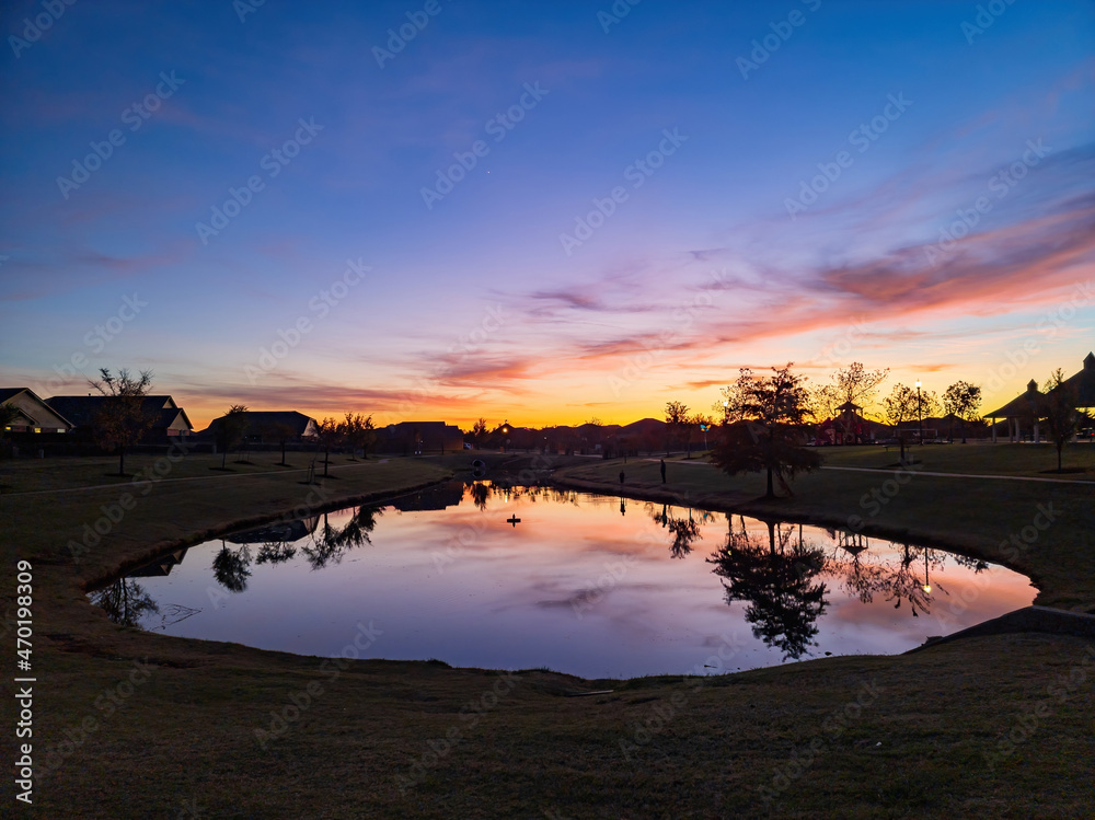 Obraz premium Sunset view of a community lake and residence