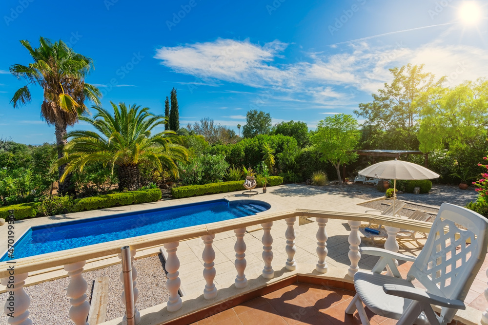 Luxurious house with a terrace, in a classic style with columns and a swimming pool. Luxurious courtyard with pool and garden with palm trees. Luxurious house with a terrace, in a classic style with columns and a swimming pool. Luxurious courtyard with pool and garden with palm trees.